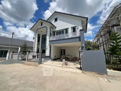 Modern two-story house with spacious driveway and contemporary design under a clear blue sky.