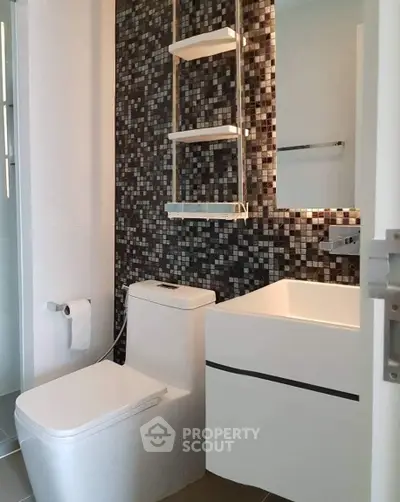 Modern bathroom with mosaic tile wall and sleek fixtures