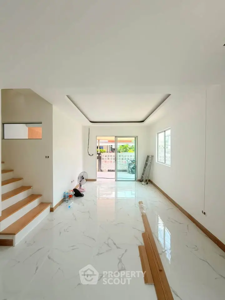 Spacious modern living room with marble flooring and large windows for natural light.