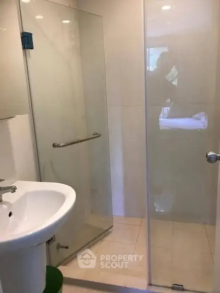 Modern bathroom with glass shower enclosure and sleek sink design.