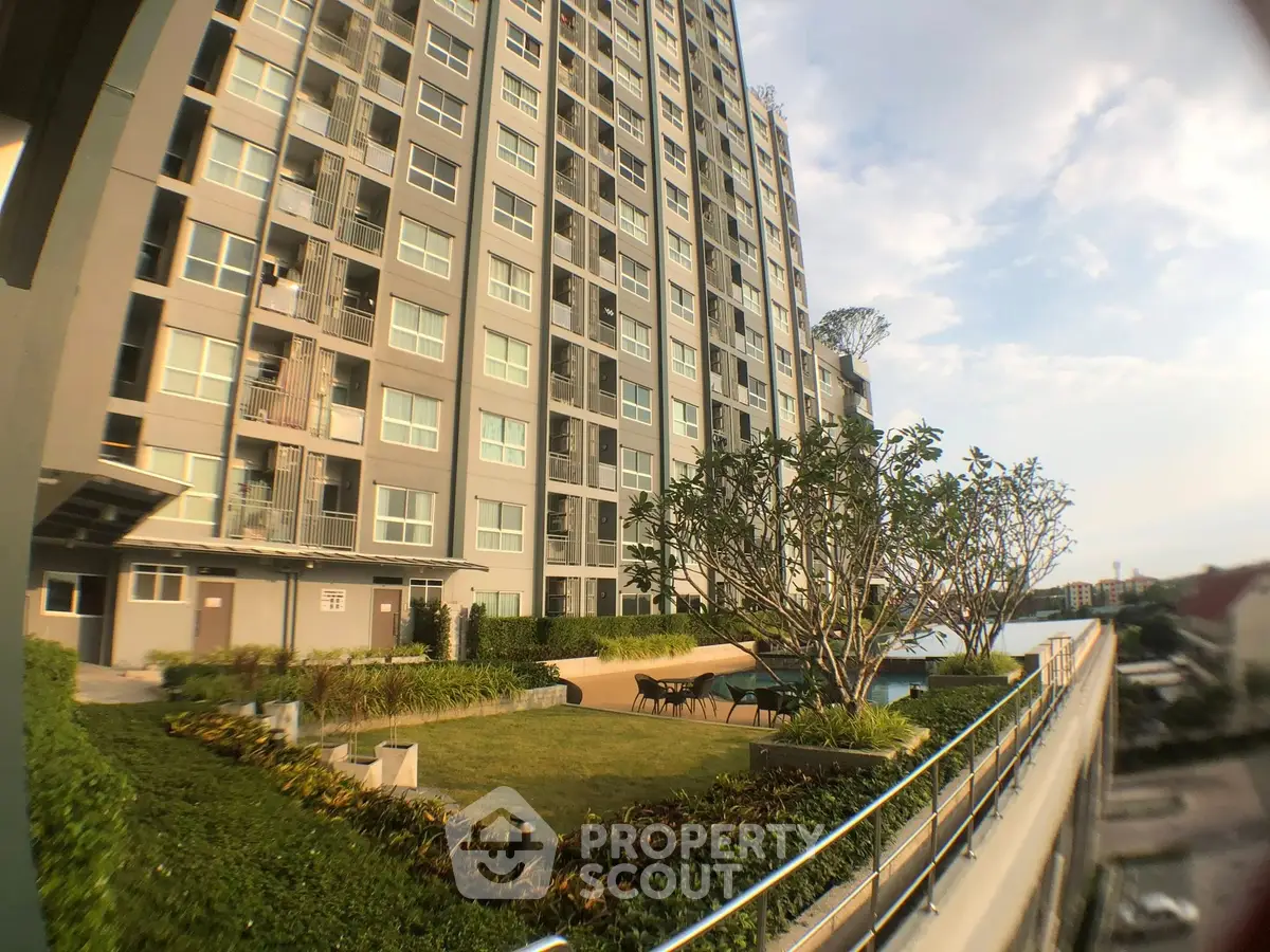 Modern high-rise building with lush garden and pool area, perfect for urban living.