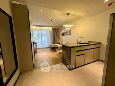 Modern open-plan kitchen and living area with elegant lighting and stylish decor.