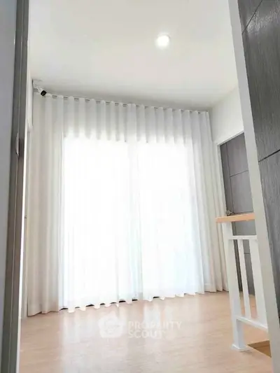 Bright and airy room with floor-to-ceiling windows and elegant white curtains.