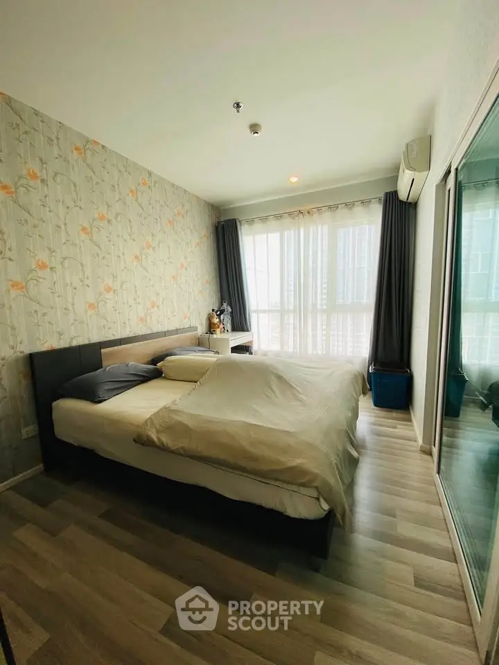 Spacious bedroom with modern decor and large windows offering natural light.