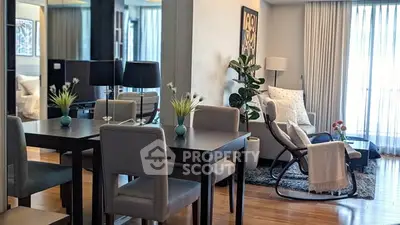 Modern living room with elegant dining area and cozy seating, featuring stylish decor and natural light.