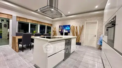 Modern kitchen with island, sleek appliances, and stylish dining area in open layout.
