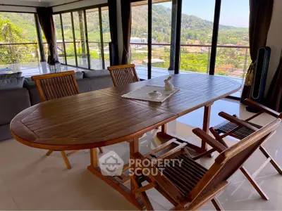 Spacious dining area with panoramic views and elegant wooden furniture in a modern home.