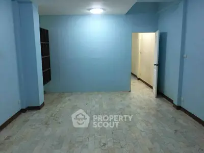 Spacious empty room with light blue walls and tiled floor, ready for customization.