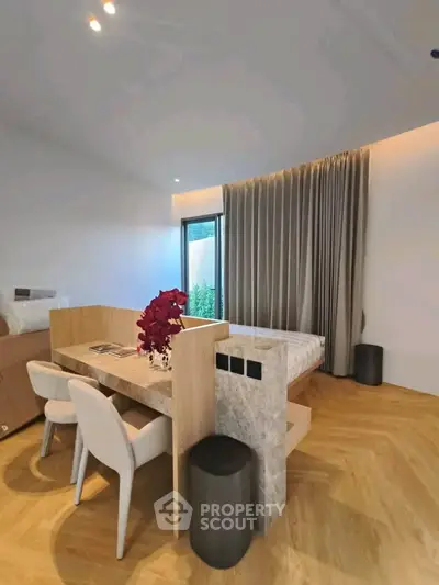 Modern bedroom with stylish decor and natural light, featuring a cozy workspace and elegant furnishings.