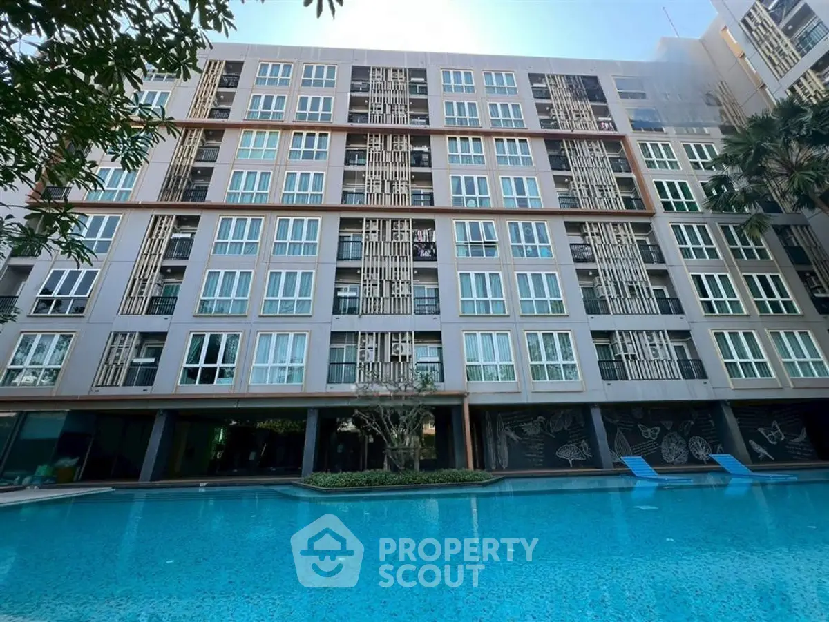 Modern apartment building with poolside view and stylish facade design.