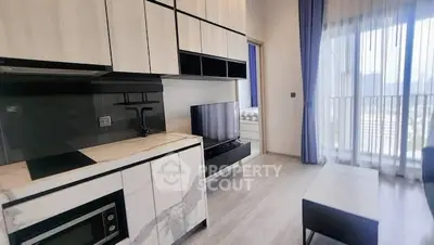 Modern living room with sleek kitchen and large windows offering city views.