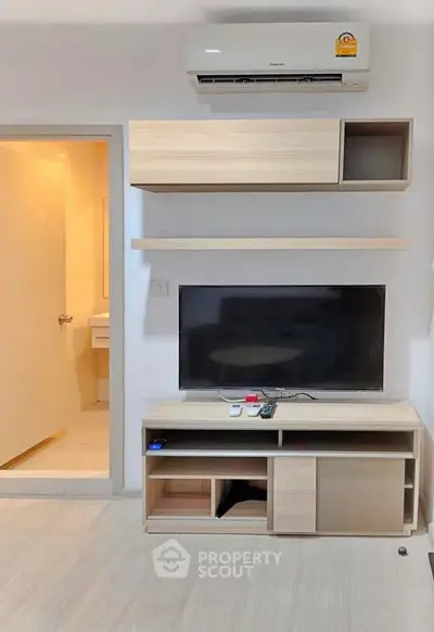 Modern living room with sleek TV unit and air conditioning, perfect for cozy entertainment.