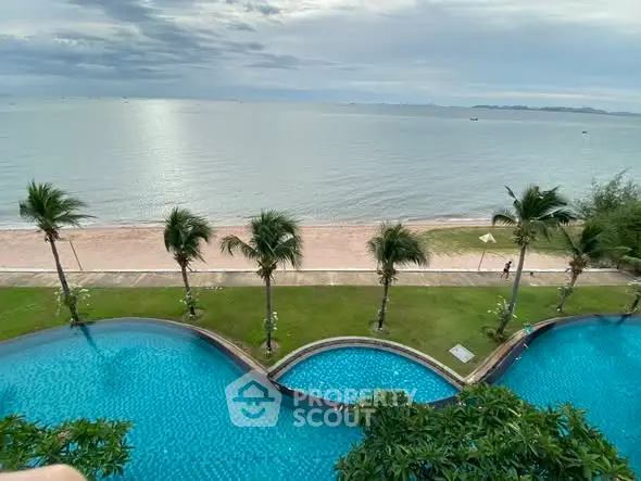 Stunning beachfront view with infinity pool and palm trees, perfect for luxury living.