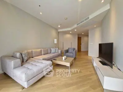 Spacious modern living room with stylish furniture and sleek wooden flooring.