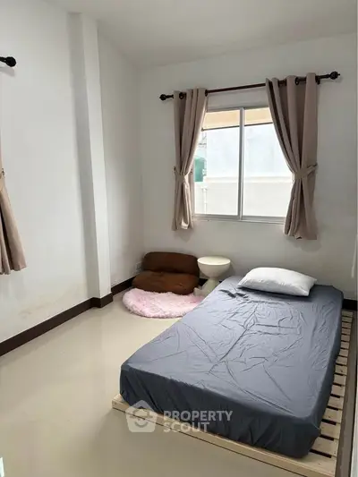 Minimalist bedroom with floor mattress and window view