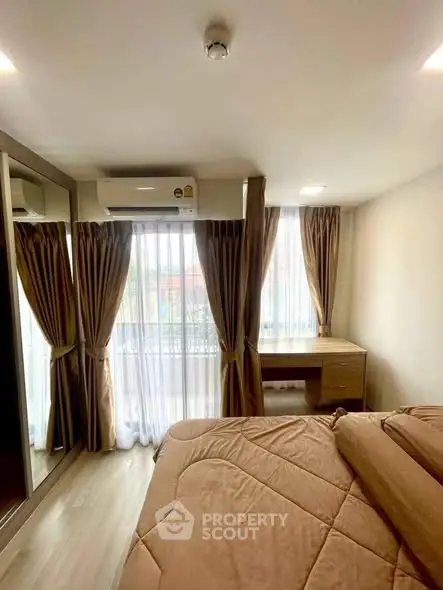 Cozy bedroom with large windows and a study desk, perfect for natural light lovers.