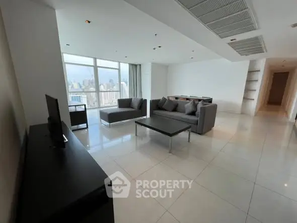 Spacious modern living room with city view and sleek furnishings.
