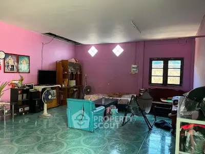 Spacious living room with vibrant pink walls and eclectic furniture arrangement.