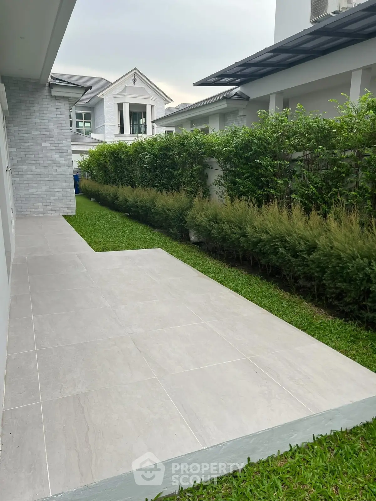 Elegant modern home exterior with lush garden and sleek tiled pathway