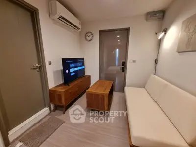 Cozy living room with modern furniture and wall-mounted TV, perfect for relaxation.