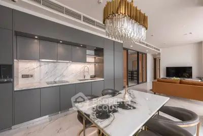 Luxurious modern kitchen with marble countertops and elegant dining area in open layout apartment.