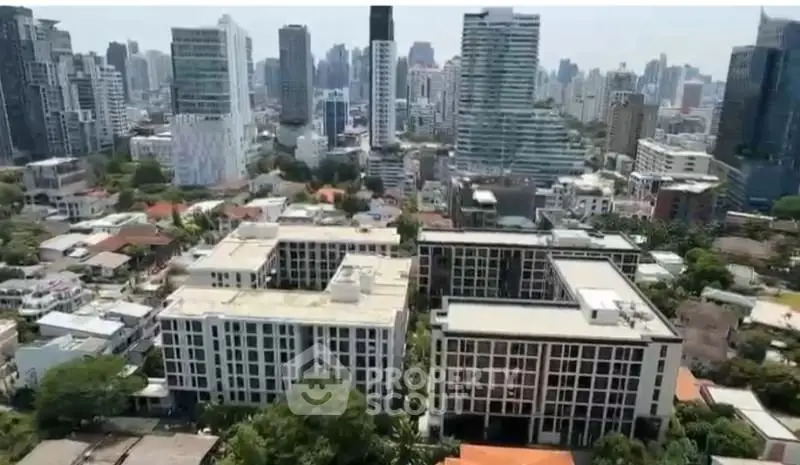 Aerial view of modern urban residential buildings with city skyline backdrop.