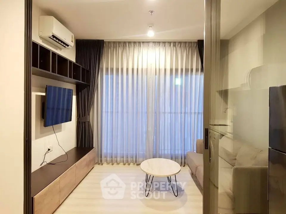 Modern living room with sleek furniture and large window, perfect for urban living.