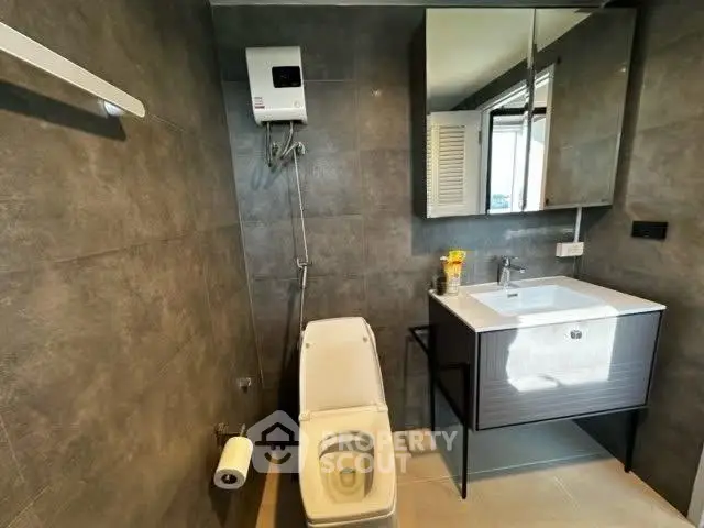 Modern bathroom with sleek fixtures and stylish gray tiles.