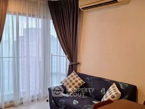 Cozy living room with stylish sofa and large window with curtains