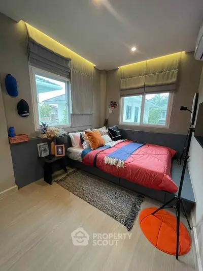 Cozy bedroom with modern decor and large windows offering natural light.