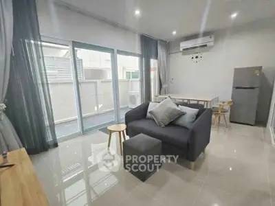 Modern living room with sleek furniture and large windows for natural light.