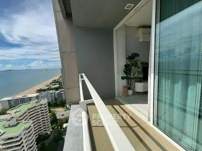 Stunning beachfront balcony with panoramic ocean views in modern high-rise apartment.