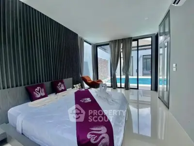 Luxurious bedroom with pool view in modern villa, featuring elegant decor and natural light.
