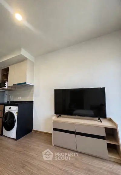 Modern living room with sleek TV stand and integrated kitchen appliances