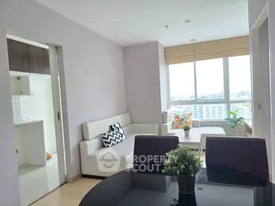 Bright and modern living room with large windows and stylish furniture in a high-rise apartment.