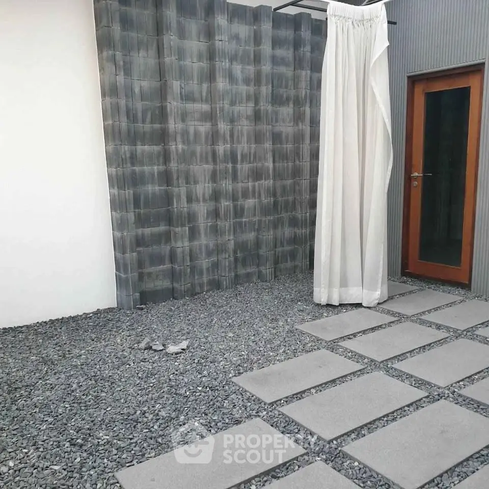 Modern minimalist courtyard with stone path and privacy curtain