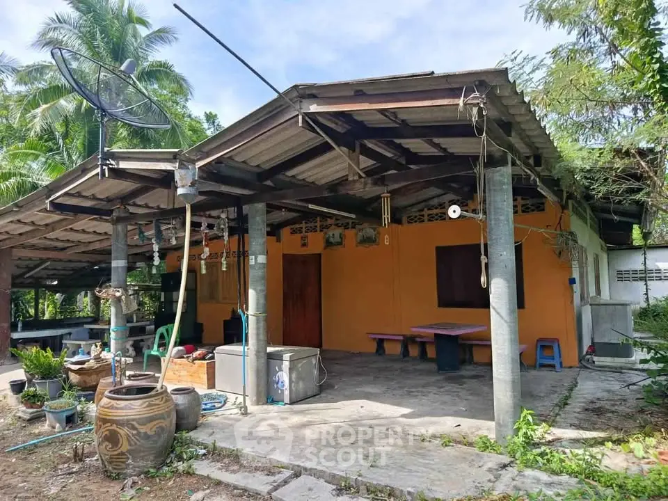 Charming rustic home with open-air patio and lush greenery, perfect for serene living.