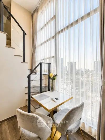Modern duplex apartment with floor-to-ceiling windows and city view, featuring elegant dining area.