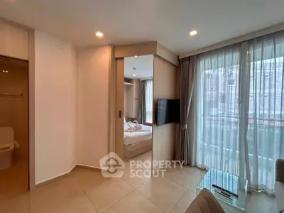 Modern apartment interior with spacious living area and bedroom view, featuring large windows and elegant decor.