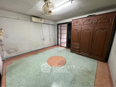 Spacious room with vintage wardrobe and ceiling fan, perfect for customization.