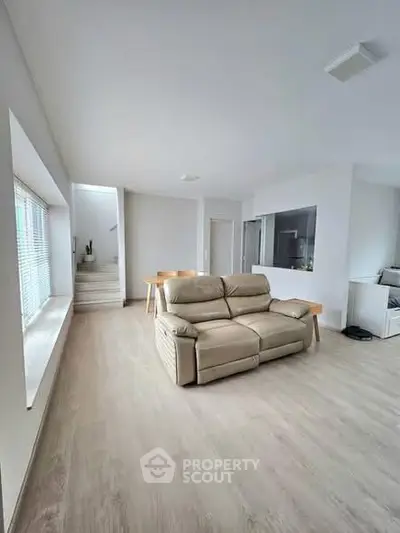 Spacious modern living room with beige sofa and large windows