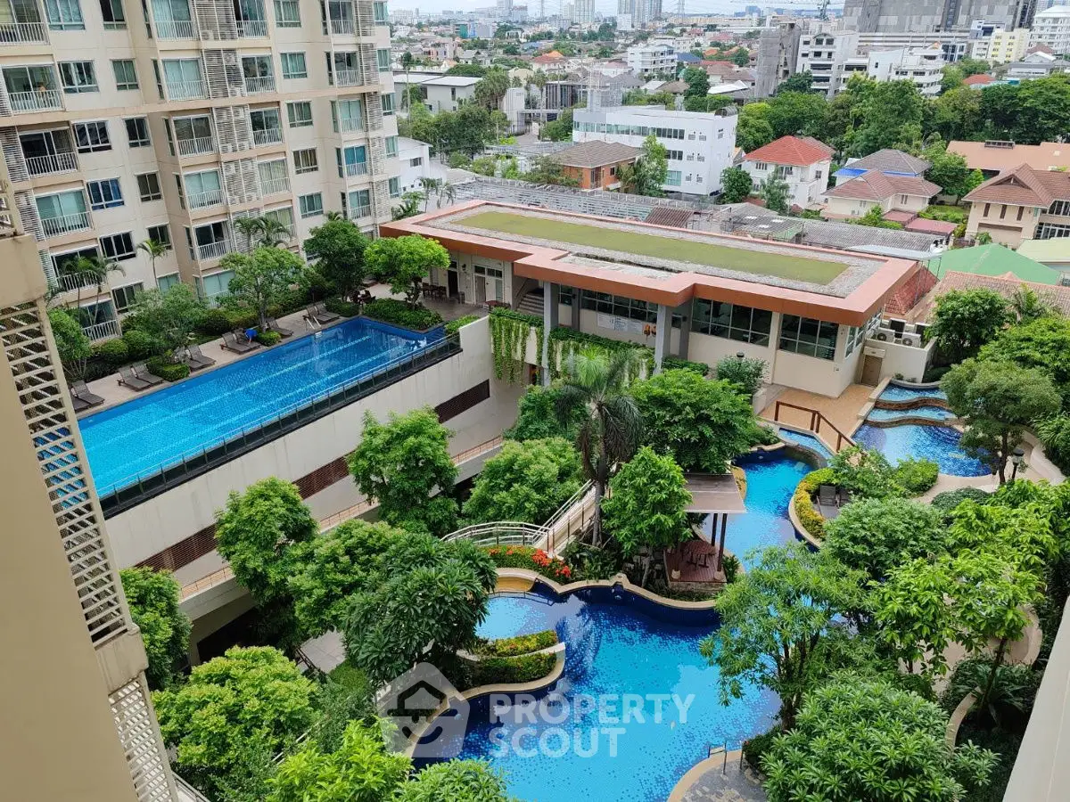 Luxurious residential complex with stunning pool and lush gardens in urban setting.