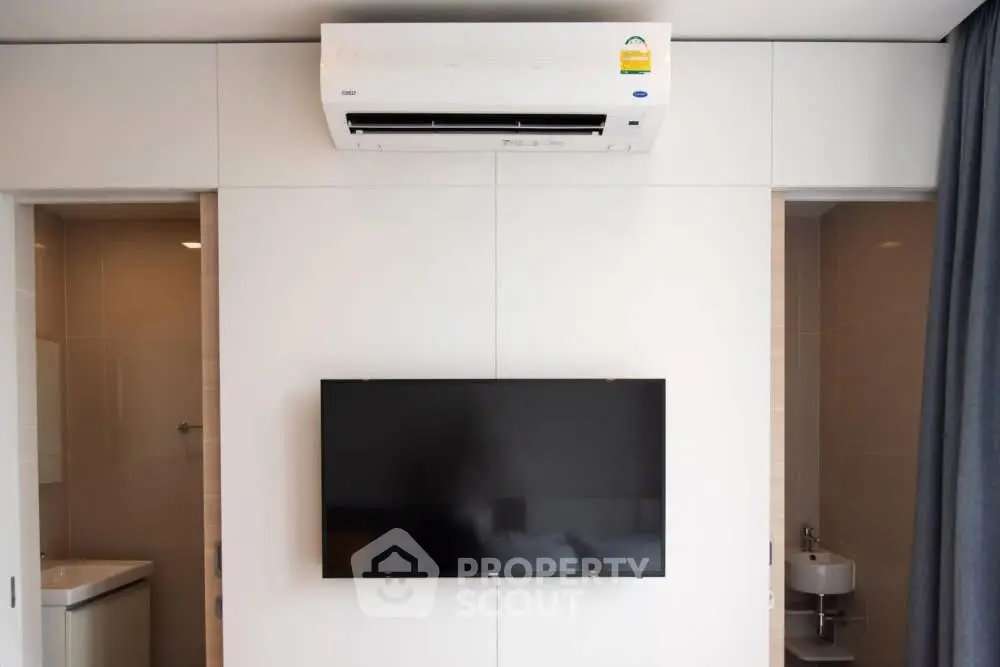 Modern interior with wall-mounted TV and air conditioning in a sleek living space.