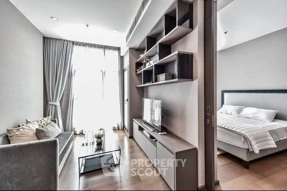 Modern apartment with cozy living room and bedroom, featuring sleek furniture and natural light.