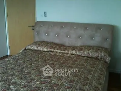 Cozy bedroom with plush headboard and floral bedding