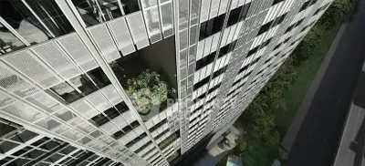 Stunning aerial view of modern high-rise building with sleek architecture and lush greenery.