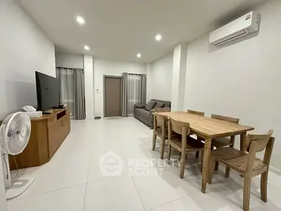 Spacious living room with modern furniture and air conditioning, perfect for family gatherings.