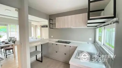 Modern kitchen with sleek design and open layout, featuring large windows and stylish cabinetry.