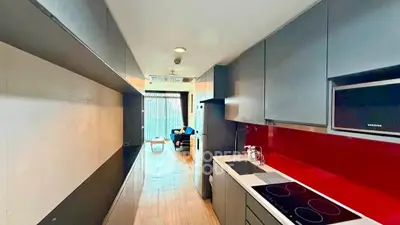 Modern kitchen with sleek cabinetry and open layout leading to a bright living area.