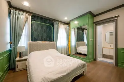 Elegant bedroom with green accents and mirrored wardrobe in modern home.